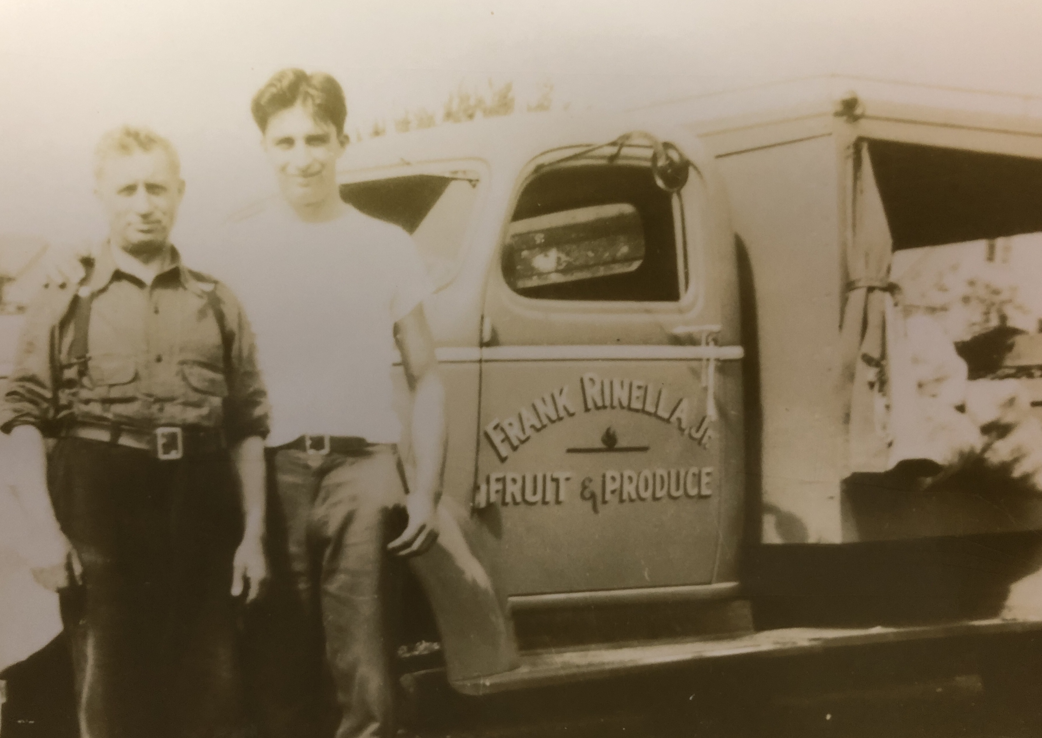 Frank Rinella Jr. and David Rinella standing in front of a Rinella Produce truck.