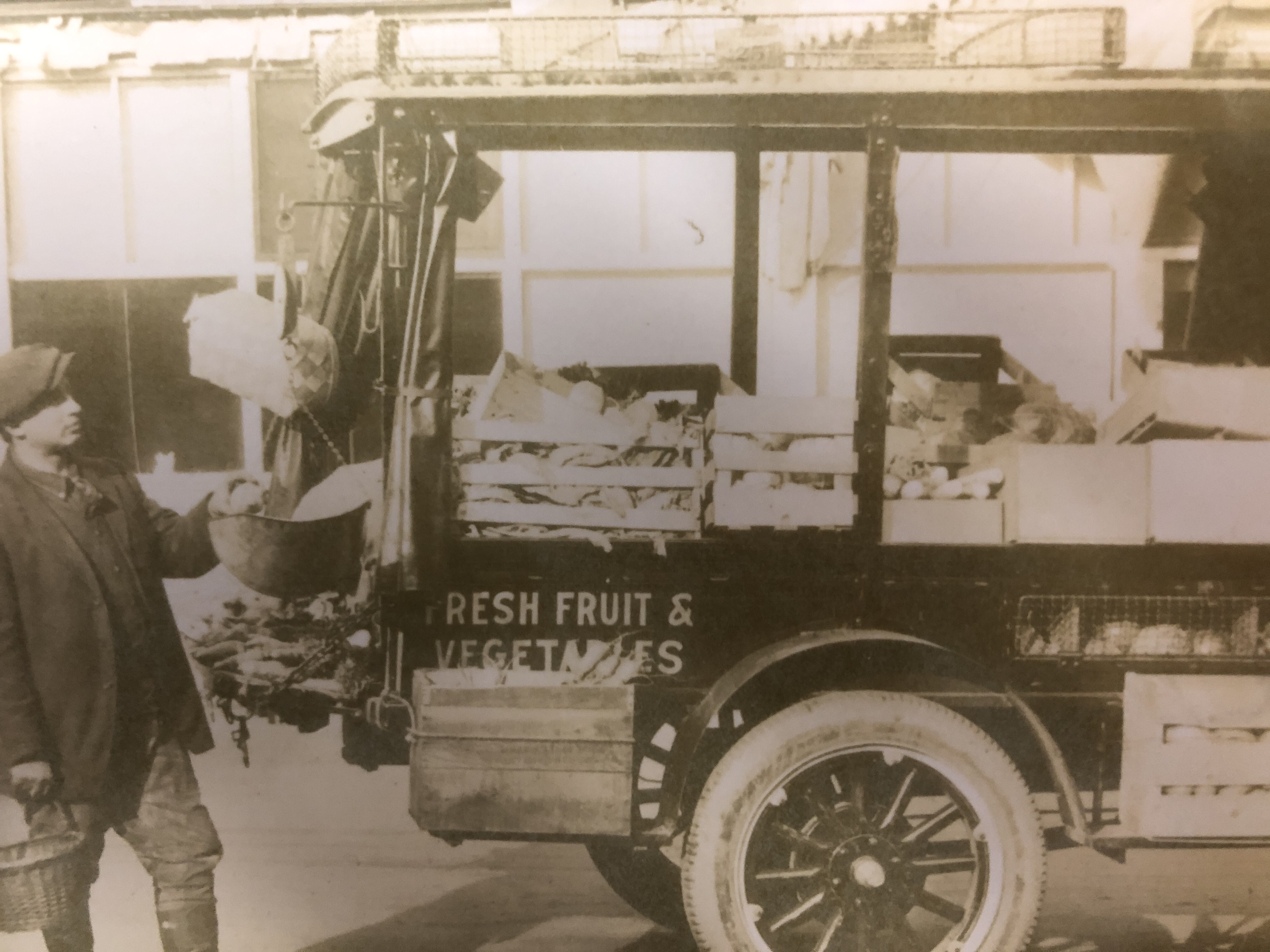 An old picture of Frank Rinella Jr. delivering fresh produce from the back of his truck.